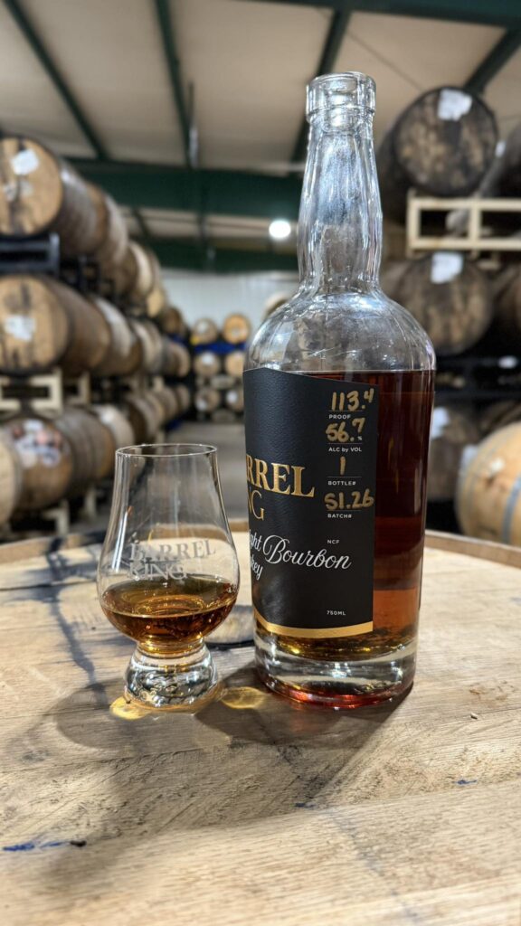 Barrel King Straight Bourbon Whiskey bottle and Glencairn glass on a barrel at Barrel King in Bourbon Missouri